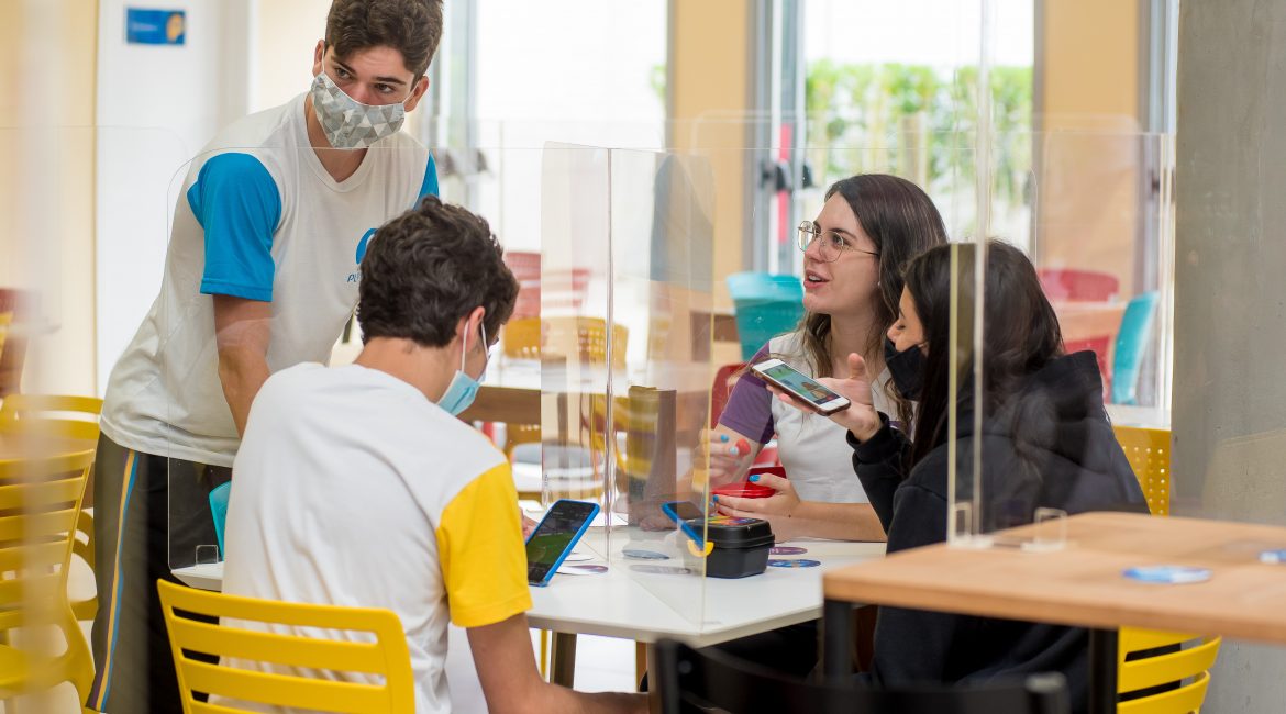 A Educação 5.0 traz a conectividade e a personalização do ensino entre as suas principais tendências. Leia nesse texto, como o Colégio Planck já atua dentro desses novos caminhos do ensino moderno. O que é Educação 5.0? Antes de mais nada, é preciso explicar do que se trata esse conceito. Há bem pouco tempo, o setor educacional vinha caminhando dentro dos critérios da Educação 4.0, adotando a tecnologia nas estratégias pedagógicas e desenvolvendo o pensamento computacional, já que o mundo vinha passando por um grande processo de digitalização. Algumas escolas, como o Colégio Planck, já contavam com tecnologias e processos para inovar a aprendizagem. No entanto, após a pandemia, essa aceleração digital tomou rumos sem precedentes e ganhou muito mais espaço nos ambientes acadêmicos. Mas, ainda que a Educação 4.0 trouxesse elementos que pudessem facilitar o processo de aprendizagem com a tecnologia, percebia-se, quase paralelamente, uma outra necessidade: integrar humanos com essas ferramentas tecnológicas e conceder aos estudantes um maior protagonismo social. É neste ponto que entra a Educação 5.0. A Educação 5.0 é totalmente baseada no desenvolvimento socioemocional, que é uma das diretrizes da BNCC. O principal objetivo é ter seres humanos que saibam sim lidar com essas novas tecnologias para produzir novas soluções, mas sejam emocionalmente maduros e estejam preparados para os desafios da vida, seja no campo pessoal, emocional ou profissional. Além da conectividade, que é própria desses novos tempos, a Educação 5.0 apresenta tendências de personalização do ensino e novos modelos, como o ensino remoto e híbrido. Conforme um relatório apresentado no Fórum Econômico Mundial, essa mudança na Educação será fundamental para atender às exigências do mercado, que tem buscado profissionais com mais criatividade, inteligência emocional, pensamento analítico, crítico e inovador, iniciativa e liderança, expertise no uso da tecnologia, programação, análise e avaliação de sistemas. Distanciamento social acelera a conectividade na Educação Segundo um relatório da ONU (The Digital Transformation Of Education: Connecting schools, empoderwing learners), o fechamento das escolas em 2020, devido à pandemia, afetou 94% dos estudantes em todo o mundo. Esse quadro fez com que a conectividade fosse mais importante do que nunca dentro da Educação. O acesso à internet foi alçado a direito fundamental e caracterizado como instrumento para efetivação de diversas oportunidades. Foi por meio da internet que as aulas continuaram sendo oferecidas, possibilitando a continuidade do currículo do ano letivo. Estar em conexão, permitiu que os estudantes assistissem às aulas, fizessem pesquisas, participassem de inúmeras atividades culturais, tours virtuais a museus, shows e teatro. Além disso, possibilitou que a socialização continuasse de um jeito diferente. No entanto, vale reforçar que essa ferramenta tecnológica não deve ser vista como substituta de relações pessoais. No caso de aulas remotas, o olhar atento do professor continuou sendo o elemento de aproximação fundamental. Esse profissional nunca poderá ser substituído por uma máquina. Enquanto o estudante usa a conectividade para continuar aprendendo, ele é auxiliado na construção desse conteúdo cognitivo pelo professor, que também atua como mediador e orientador. Por isso, nesse momento, também revelou-se a grande importância de qualificar os professores e desenvolver neles as competências adequadas para o uso da tecnologia. Portanto, para se enquadrar dentro da Educação 5.0 é válido entender que a conectividade na escola é muito importante, pode aproximar e dar continuidade a projetos pedagógicos, porém, deve servir como uma ferramenta que é alimentada pelos seres humanos. O que é a personalização na Educação? A forma de ensinar tem sido a mesma durante décadas, ou seja, o mesmo conteúdo é repassado a todos os estudantes, não oferecendo a eles uma possibilidade de escolha. Esse modelo funcionou bem durante um bom tempo, porém, na atualidade, não é estimulante para as novas gerações. A personalização da Educação vem mudar isso e faz parte de um ciclo natural de mudanças, próprio de um tempo no qual a inovação e a criatividade estão muito em evidência. Neste cenário, é preciso entender que cada estudante tem suas próprias características pessoais, interesses, desempenho acadêmico, desenvolvimento pessoal e capacidade de adaptação. Assim, essa personalização visa oferecer possibilidades que sejam adequadas às necessidades individuais de cada estudante. Ao oferecer experiências de aprendizagem diversificadas, é possível fazer uma melhor avaliação da forma de cada estudante aprender. Como funciona a Educação 5.0 no Colégio Planck? O Colégio Planck tem DNA altamente tecnológico, o qual o qualifica como um ótimo exemplo de metodologia de ensino baseada na Educação 4.0, porém, entre seus pilares também está o desenvolvimento socioemocional, portanto, também está totalmente mergulhado nas novas possibilidades oferecidas pela Educação 5.0. Altamente facilitadores dentro da proposta pedagógica do Colégio, os recursos tecnológicos fazem parte do dia a dia dos estudantes do Planck. Durante a pandemia, foram esses recursos tecnológicos, e uma equipe altamente especializada, que permitiram que o nível do ensino do Colégio continuasse alto mesmo durante o isolamento social e adoção do estudo remoto, quando todas as escolas precisaram fechar as portas para as aulas presenciais a partir de março de 2020. Neste período não foi deixado de lado o pilar socioemocional e olhar individualizado para os estudantes. Assim, professores, coordenadores, orientação e direção estiveram ainda mais atentos à qualidade e ao trabalho realizado. Além disso, o Colégio Planck sempre ofereceu disciplinas eletivas para que os estudantes tivessem uma gama ainda maior de oportunidades de conhecimento, desde que foi inaugurado há 5 anos. Atualmente, são 38 eletivas, com as quais os estudantes têm a oportunidade de investir em áreas que atendem a seus interesses pessoais. Para o Novo Ensino Médio, que entra em vigor em 2022, o Colégio Planck também vai oferecer, além da formação geral básica, 24 opções de trilhas anuais, que vai permitir que os estudantes tenham mais autoconhecimento, desenvolvimento da autonomia nas escolhas profissionais e escolhas de futuro. Conclusão Assim como em todas as áreas, a Educação também faz as suas mudanças de acordo com as exigências do tempo e das expectativas do mundo. Usando a conectividade, personalização de ensino, que abrirá seus horizontes para novas possibilidades e modelos, como o híbrido; pode-se dizer que com a Educação 5.0 nada será como antes, e que os estudantes vão ganhar muito mais elementos para buscar o que os tornará mais felizes, não só na escola, mas na vida em geral. No Colégio Planck, as ferramentas serão dadas, e cada vez mais a autonomia e o protagonismo dos estudantes ganharão força, para que eles saibam seguir os próprios caminhos, com preparo e segurança.