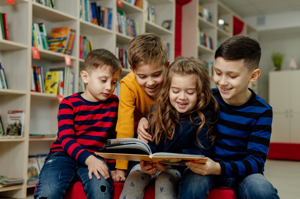 Você sabe como promover o interesse pela leitura em crianças do fundamental anos iniciais? A leitura é uma habilidade fundamental que contribui para o desenvolvimento cognitivo, social e emocional de uma criança, mas muitas vezes é desafiador fazê-las ter interesse em ler. Neste texto, conheça algumas estratégias eficazes para incentivar a leitura nos estudantes dessa faixa etária. Como promover o interesse pela leitura? Incentivar a leitura em idade precoce pode ajudar as crianças em seus processos de aprendizagem ao longo da vida, porque aprimora diversas competências e habilidades importantes na formação intelectual e emocional. Entre algumas vantagens da leitura, estão ajudar a desenvolver o vocabulário e também estimular a curiosidade das crianças por novos conhecimentos. Mas existe muitos outros benefícios de estimular o hábito da leitura entre as crianças, como: Traz desenvolvimento cognitivo apoiado; Aprimoramento das habilidades linguísticas; Traz boas estruturas de linguagem; Melhora habilidades de escrita; Estimula foco e concentração; Melhora habilidades de pensamento crítico; Estimula o uso da memória; Melhora imaginação e criatividade; Melhora habilidades de resolução de problemas; Fortalece as conexões cerebrais; Ajuda a aliviar o estresse; Amplia repertório de conhecimento na tenra idade; Prepara o estudante para o sucesso acadêmico; Assim, é mais que importante promover o interesse pela leitura entre as crianças desde cedo 
