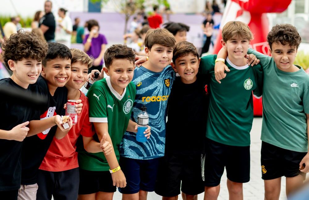 Grupo de meninos reunidos e sorrindo durante uma atividade coletiva, representando as diferentes fases e emoções abordadas no “Emocionário de cada série” do Colégio Planck.