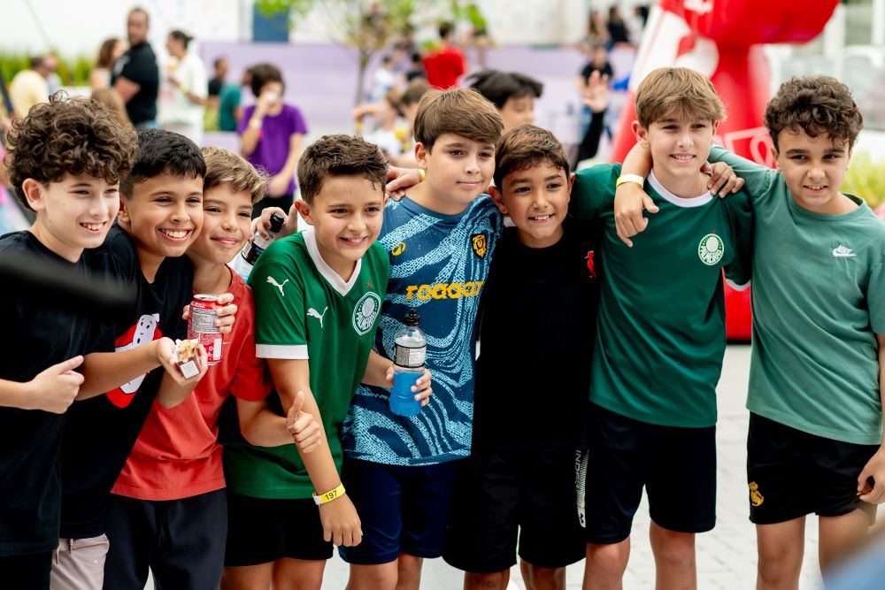 Grupo de meninos reunidos e sorrindo durante uma atividade coletiva, representando as diferentes fases e emoções abordadas no “Emocionário de cada série” do Colégio Planck.