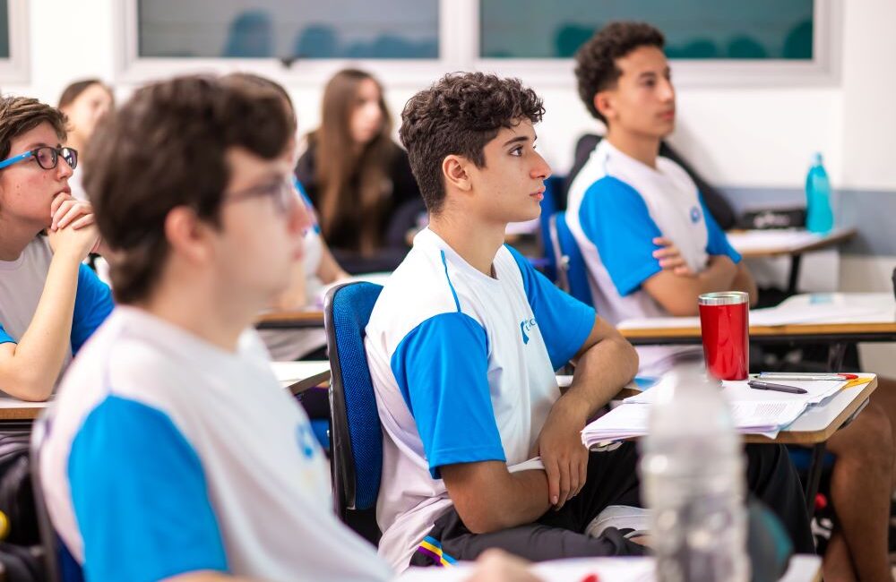 Estudantes concentrados na sala de aula.