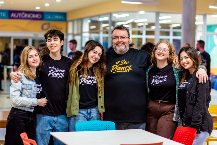 Estudantes abraçados com diretor do colégio.