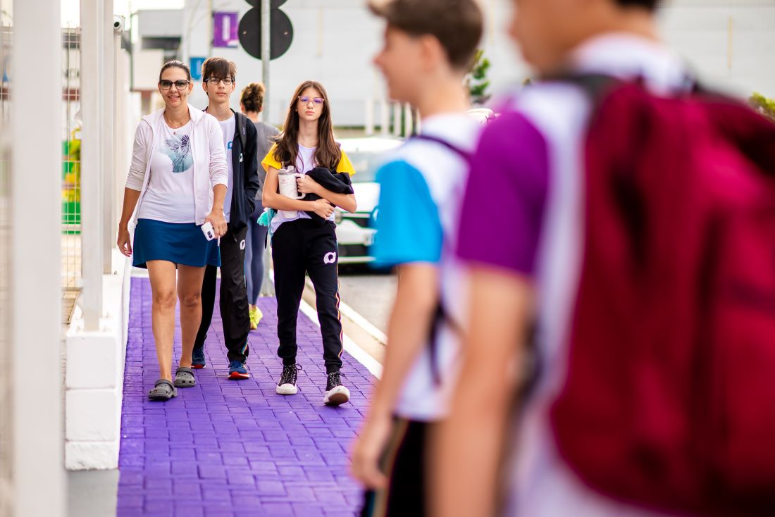 Pais e filhos caminhando para escola.