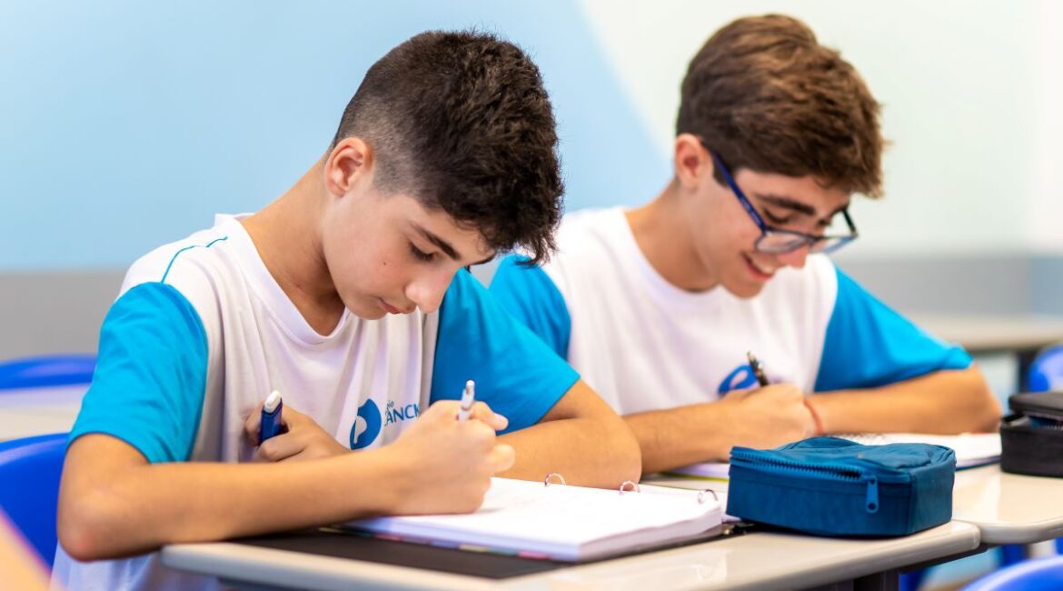 Estudantes concentrados em estudo na sala de aula.