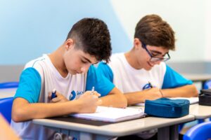 Estudantes concentrados em estudo na sala de aula.