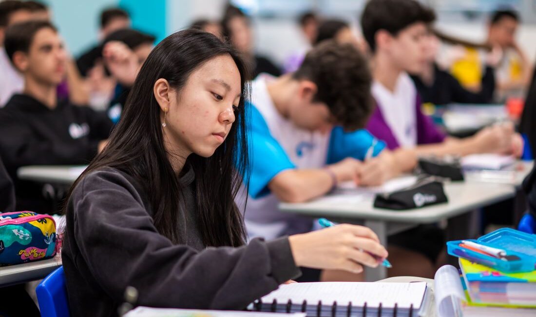 Estudantes concentrados em sala de aula.