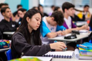 Estudantes concentrados em sala de aula.