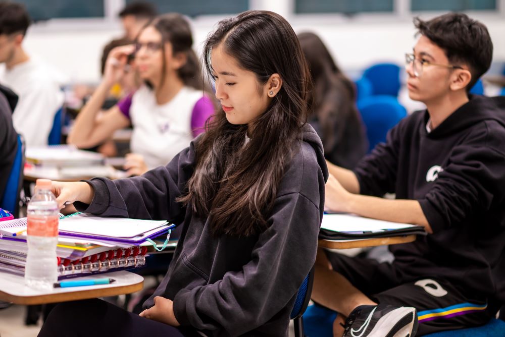 Estudantes do Colégio Planck sentados em carteira em sala de aula.