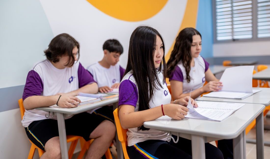 Estudantes prestando atenção na aula, exemplificando que estão refletindo sobre as estratégias para o próximo ciclo de acordo com os resultados das provas.