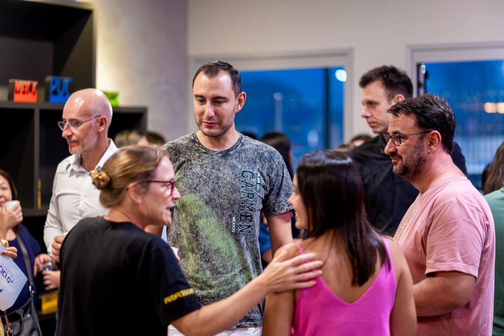 Famílias de alta performance em reunião de escola dos filhos conversando com equipe pedagógica.
