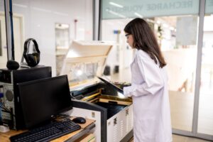 Estudante manuseando máquina de corte a laser em laboratório escolar moderno, representando o protagonismo, a tecnologia e o aprendizado prático no Colégio Planck.