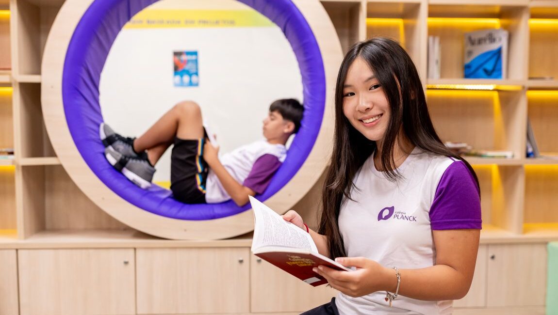Estudante no ambiente do Colégio Planck com design moderno e pod de leitura: exemplo de espaço que estimula a educação exponencial.