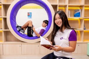 Estudante no ambiente do Colégio Planck com design moderno e pod de leitura: exemplo de espaço que estimula a educação exponencial.