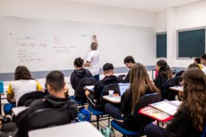 Estudante refletindo sobre o tempo e o imediatismo, representando a dificuldade de esperar na cultura contemporânea.