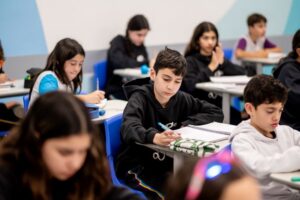 Estudantes do Colégio Planck concentrados em sala de aula, organizando cadernos e materiais durante a rotina estruturada de estudos no Ensino Fundamental II.
