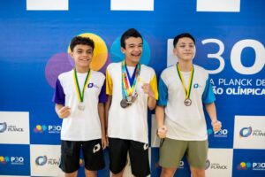 Estudantes com medalhas em evento escolar demonstrando o impacto das extracurriculares no desempenho acadêmico.