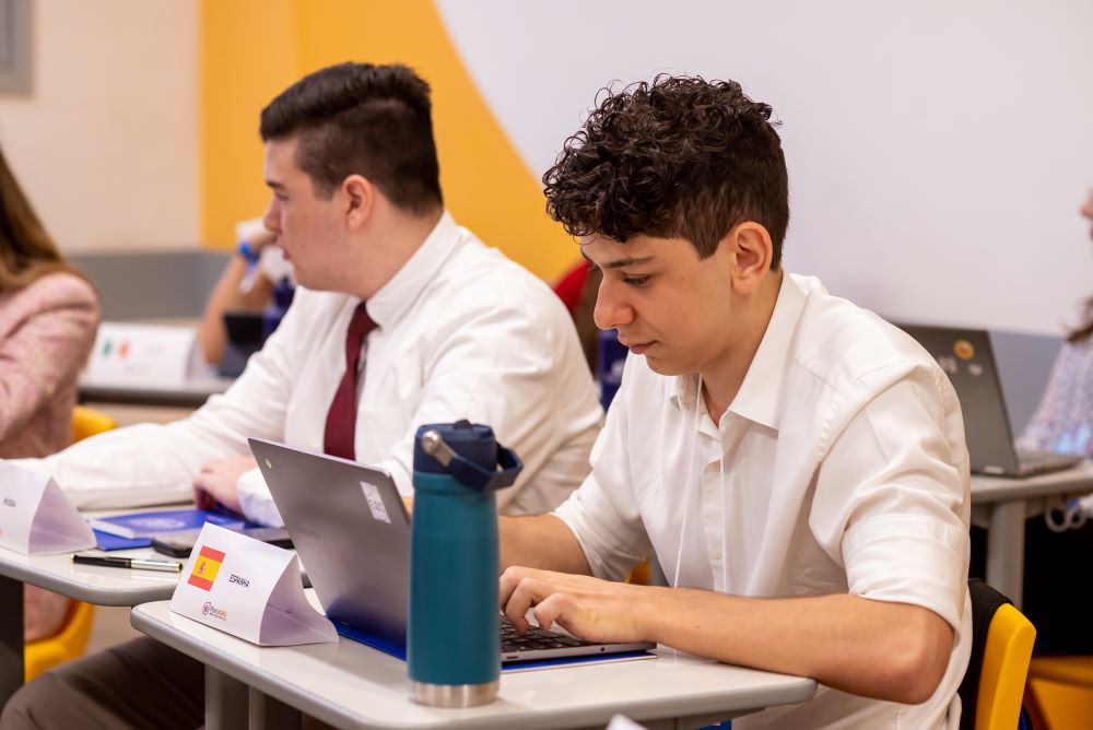 Estudantes do Colégio Planck participam de atividade acadêmica com notebooks em sala de aula, representando dedicação aos estudos e preparação para oportunidades internacionais como a Lester B. Pearson Scholarship.

