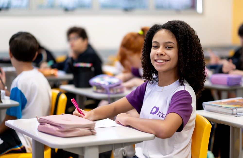 Estudante organizada em sala de aula com materiais escolares, representando gestão do tempo, autonomia e hábitos de estudo no Ensino Fundamental.