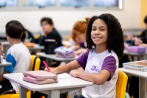 Estudante organizada em sala de aula com materiais escolares, representando gestão do tempo, autonomia e hábitos de estudo no Ensino Fundamental.